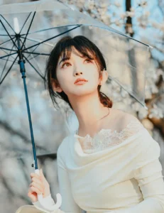Femme élégante tenant un parapluie transparent en extérieur